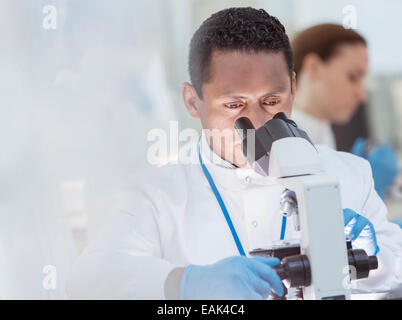 Scientist examining sample under microscope in laboratory Stock Photo