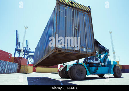 Low angle view of crane lifting cargo container Stock Photo