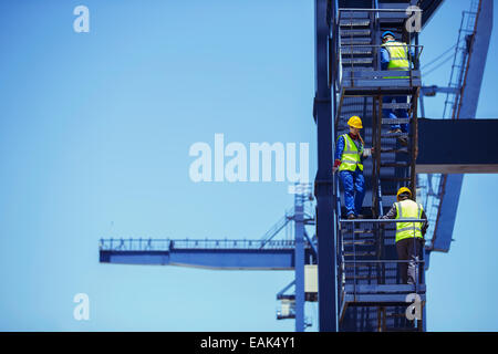 Workers climbing cargo crane Stock Photo