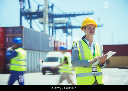 Businesswoman using digital tablet near cargo containers Stock Photo