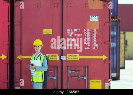 Businesswoman smiling near cargo containers Stock Photo