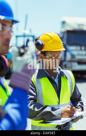 Worker writing on clipboard Stock Photo