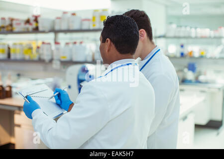 Scientists taking notes in laboratory Stock Photo