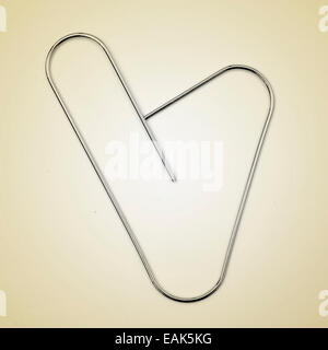 picture of a heart-shaped paperclip on a beige background, with a retro effect Stock Photo