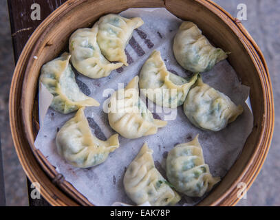 momo dumplings with spinach steamed in bamboo basket Stock Photo