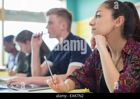 Female student contemplating in classroom Stock Photo