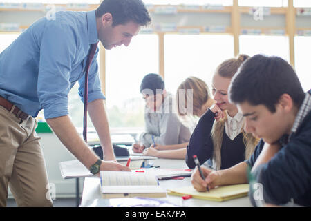Teacher helping his students in classroom Stock Photo