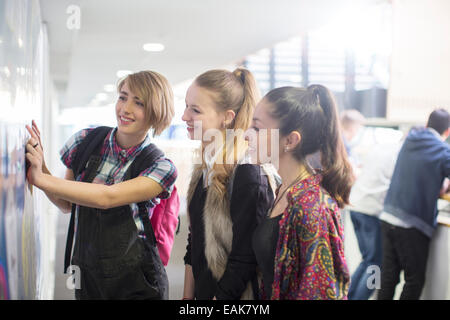 Three female students checking exam results in school corridor Stock Photo