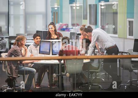 Students during IT lesson in modern classroom with glass walls Stock Photo