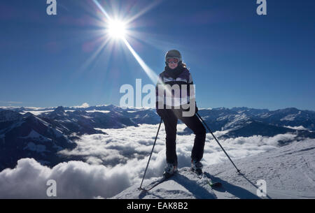 Young woman with ski equipment against Alps mountains, Austria Stock Photo