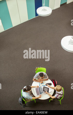Overhead view of student doing homework, using laptop and digital tablet Stock Photo