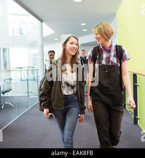 Group of cheerful students walking in corridor Stock Photo