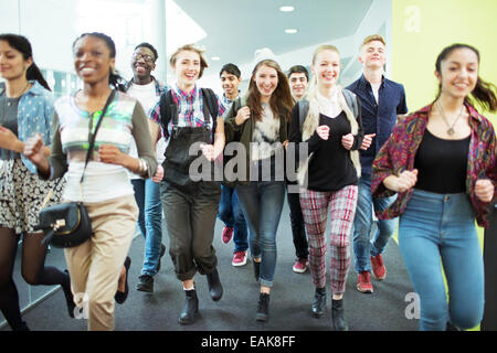 Group of cheerful students running in corridor Stock Photo