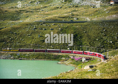 Rhaetian Railway, Bernina Express at Lago Bianco lake, Bernina Pass, Pontresina, Canton of Graubünden, Switzerland Stock Photo