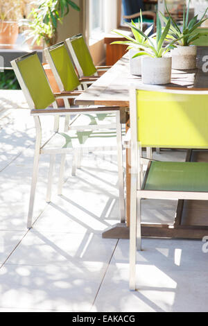 Chairs and table with potted plants on patio Stock Photo