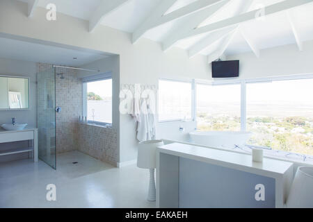 Modern white bathroom interior with large bathtub and shower area Stock Photo