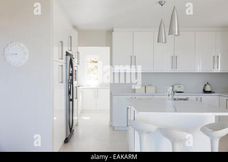 Modern white and clean kitchen interior with stools at counter Stock Photo