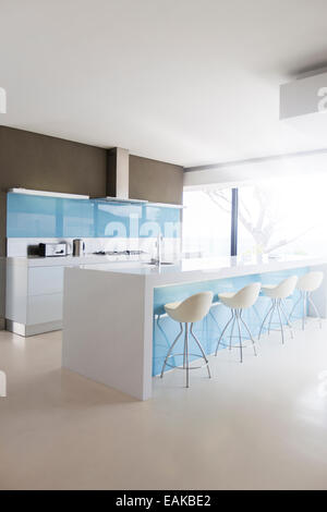 White and clean modern kitchen with stools at kitchen island Stock Photo