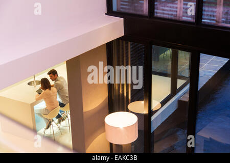 Elevated view of couple using tablet pc in dining room Stock Photo