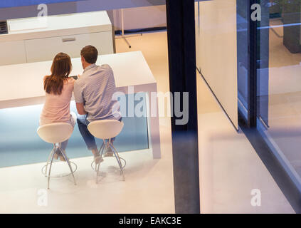 Rear view of couple using tablet pc in dining room Stock Photo