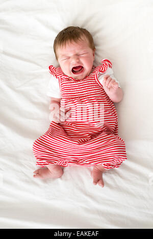 Four day old newborn baby girl crying loudly Stock Photo