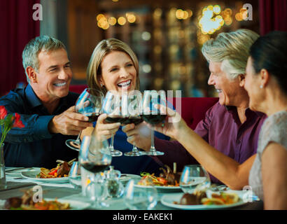 People toasting with red wine in restaurant Stock Photo