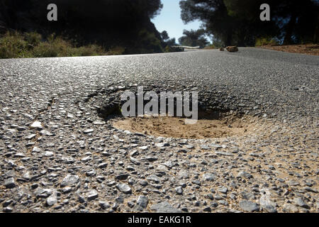 Low view of pothole in tarmac Asphalt in mountains of Mijas, Andalusia, Spain. Stock Photo