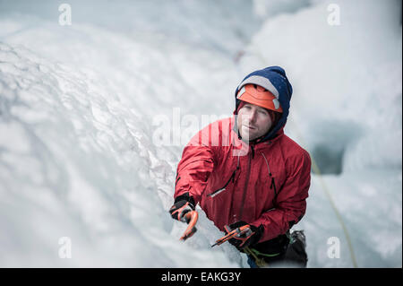 Man lead climbing an ice fall in Simplon Pass, Valais, Switzerland. Stock Photo