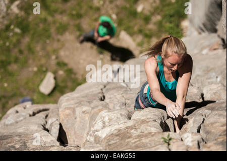 Italian girl climbs a 6b crack route in Balmanolesca, the most historical granite crag in Ossola. Varzo, Italy. Stock Photo
