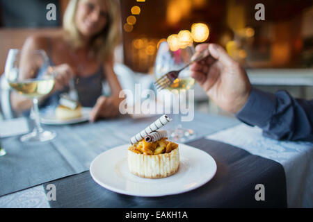 Couple eating dessert in fancy restaurant