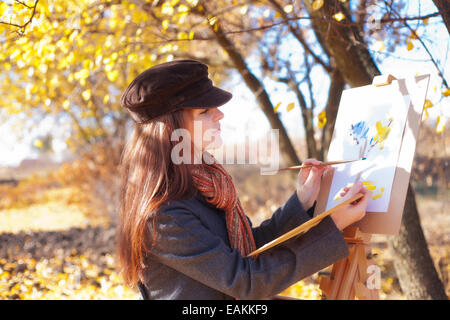 The girl is engaged in painting on nature Stock Photo