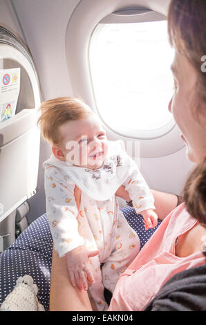 Travelling on an aeroplane with a two month old baby girl Stock Photo