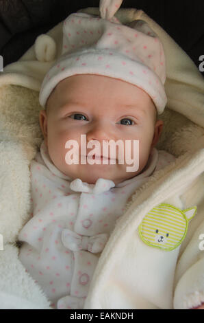 A baby girl (ca. 2 months old) in warm clothing. Stock Photo