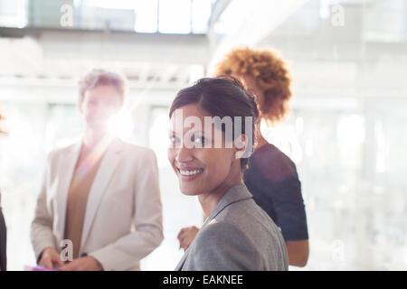 Portrait of smiling businesswoman with colleagues in background Stock Photo