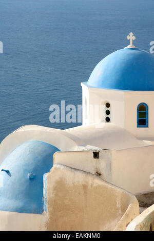 Traditional white church with a Blue dome, perched on the side of the cliff, Oia, Santorini, Cyclades Islands, Greece. Stock Photo