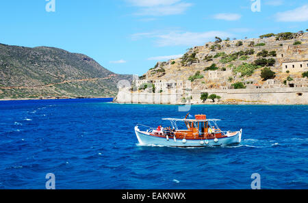 The motor yacht with tourists is near Spinalonga island, Greece Stock Photo