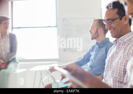 People working on tablets and laptops in office Stock Photo