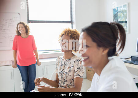 Three women laughing during meeting in office Stock Photo
