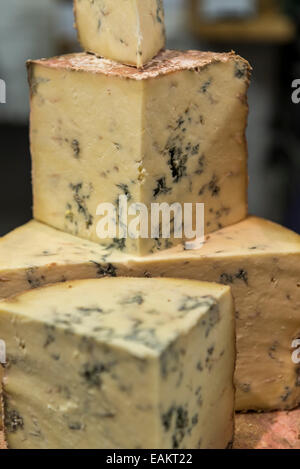 Stack of different sized portions of blue cheese on display Stock Photo