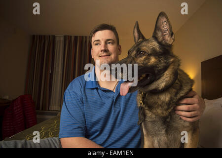 Nov. 15, 2014 - Fayetteville, NC - Army Spc. BRENT GROMMET was reunited with Matty, his U.S. Army trained German Shepherd, after being separated for more than a year. Both had been injured in the war. Grommet, now 23, came back from Afghanistan with traumatic brain injury, hearing loss and spinal-cord injury. Despite the veteran's right to adopt Matty, the bomb-detecting service dog mysteriously ended up another family with who took a liking to him and adopted him instead. Grommet's dad Don persevered for more than a year to locate Matty, despite threats of prison to his son from military off Stock Photo