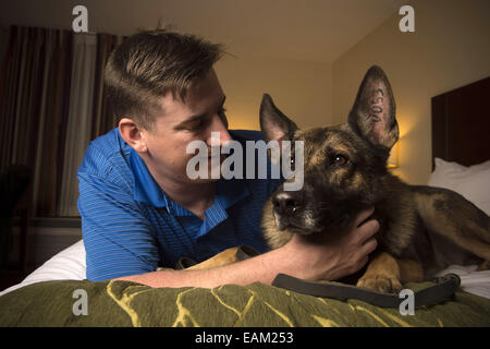 Nov. 15, 2014 - Fayetteville, NC - Army Spc. BRENT GROMMET was reunited with Matty, his U.S. Army trained German Shepherd, after being separated for more than a year. Both had been injured in the war. Grommet, now 23, came back from Afghanistan with traumatic brain injury, hearing loss and spinal-cord injury. Despite the veteran's right to adopt Matty, the bomb-detecting service dog mysteriously ended up another family with who took a liking to him and adopted him instead. Grommet's dad Don persevered for more than a year to locate Matty, despite threats of prison to his son from military off Stock Photo