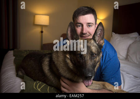 Nov. 15, 2014 - Fayetteville, NC - Army Spc. BRENT GROMMET was reunited with Matty, his U.S. Army trained German Shepherd, after being separated for more than a year. Both had been injured in the war. Grommet, now 23, came back from Afghanistan with traumatic brain injury, hearing loss and spinal-cord injury. Despite the veteran's right to adopt Matty, the bomb-detecting service dog mysteriously ended up another family with who took a liking to him and adopted him instead. Grommet's dad Don persevered for more than a year to locate Matty, despite threats of prison to his son from military off Stock Photo