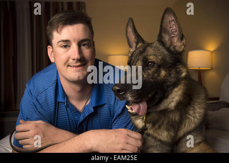 Nov. 15, 2014 - Fayetteville, NC - Army Spc. BRENT GROMMET was reunited with Matty, his U.S. Army trained German Shepherd, after being separated for more than a year. Both had been injured in the war. Grommet, now 23, came back from Afghanistan with traumatic brain injury, hearing loss and spinal-cord injury. Despite the veteran's right to adopt Matty, the bomb-detecting service dog mysteriously ended up another family with who took a liking to him and adopted him instead. Grommet's dad Don persevered for more than a year to locate Matty, despite threats of prison to his son from military off Stock Photo