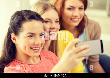 smiling teenage girls with smartphone at home Stock Photo