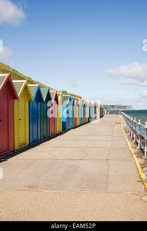 Brightly coloured beach huts on the sea front at Whitby, Yorkshire, UK. Stock Photo