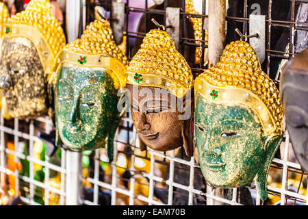 traditional thai buddha wooden masks on sale in a market stall Stock Photo