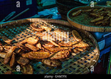 cooking meat skewers on the grill in a thai food street market in bangkok Stock Photo