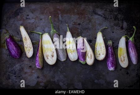 Fairytale Eggplants, Halved on Dark Pan Stock Photo