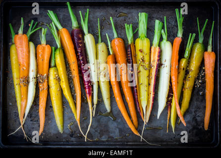 Rainbow Carrots with Olive Oil and Spices on Dark Vintage Pan Stock Photo