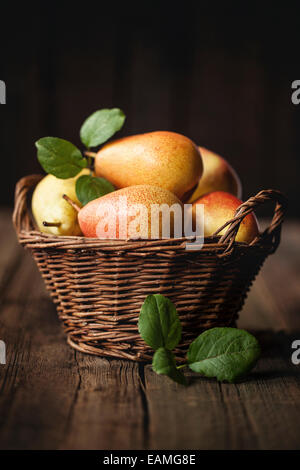 Pears in a basket over dark background Stock Photo